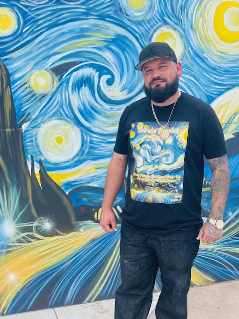 Artist Leo Alvarez with his mural of Vincent van Gogh’s Starry Night at World Bipolar Day 2025.
